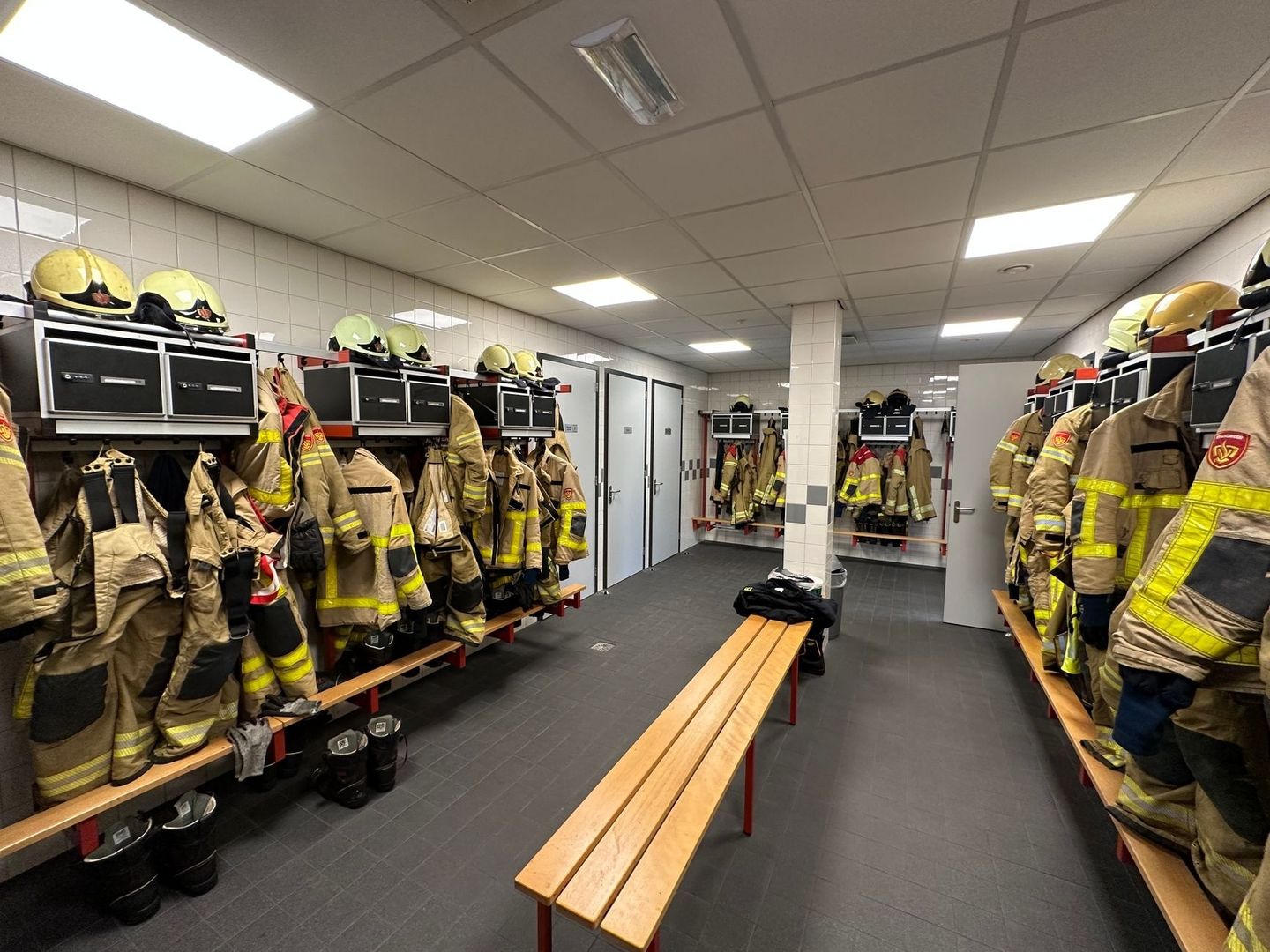 Umkleideraum mit Einsatzkleidung und Helmen der Feuerwehr